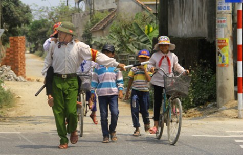 Hai người đàn ông tình nguyện dẫn học sinh qua đường